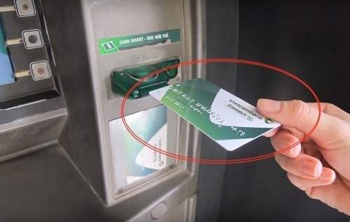 cho thẻ vào khe của cây ATM 